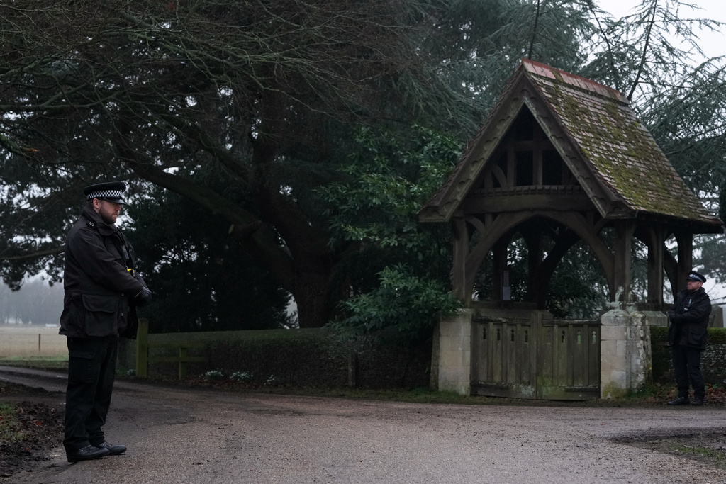 Police officers guard the entrance to the Sandringham Royal Estate in Sandringham, England, Thursday, Feb. 19, 2026 after Andrew Mountbatten-Windsor was arrested by British police on suspicion of misconduct in public office. (AP Photo/Alastair Grant)