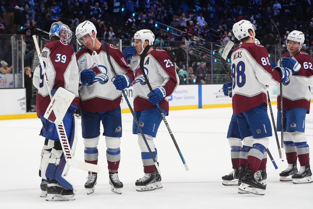 Colorado Avalanche goaltender Mackenzie Blackwood (39) celebrates a win against the Seattle Kraken with center Brock Nelson, second from left, and center Nathan MacKinnon, third from left, after of an NHL hockey game Tuesday, Dec. 16, 2025, in Seattle. (AP Photo/Lindsey Wasson)