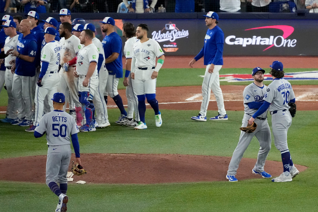 Los Angeles Dodgers' pitcher Justin Wrobleski (70) is held back by Los Angeles Dodgers' Max Muncy after hitting Toronto Blue Jays' Andrés Giménez with a pitch causing the benches to clear during the fourth inning in Game 7 of baseball's World Series, Saturday, Nov. 1, 2025, in Toronto. (AP Photo/Ashley Landis)