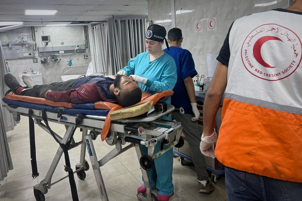 This photo provided by American nurse Andee Vaughan, shows Vaughan as she attends to a man injured by explosives, at al-Quds hospital in Gaza City on July 21, 2025. (Courtesy Andee Vaughan via AP)