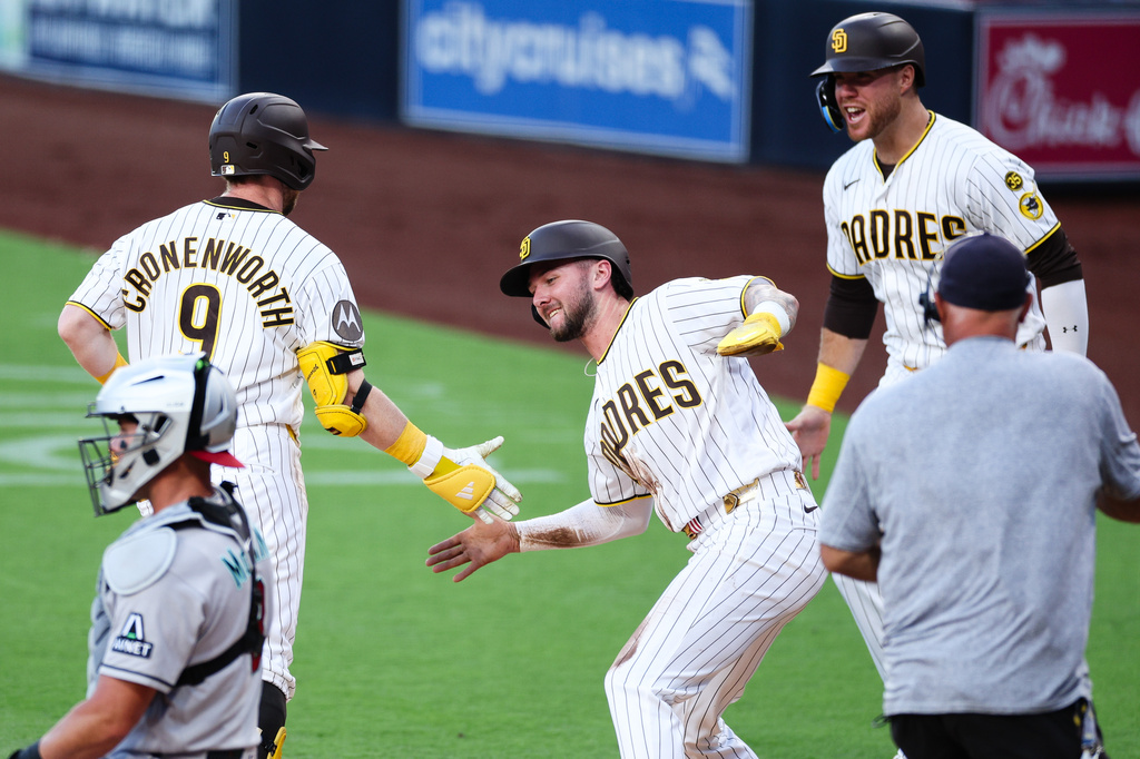 San Diego Padres' Jackson Merrill, center, congratulates Jake Cronenworth (9) after he hit a three-run home run against the Arizona Diamondbacks as Gavin Sheets looks on in the first inning of a baseball game Tuesday, July 7, 2026, in San Diego. (AP Photo/Derrick Tuskan)