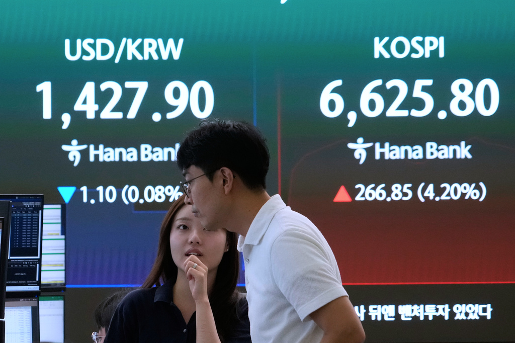 Currency traders work near a screen showing the Korea Composite Stock Price Index (KOSPI) and the foreign exchange rate between U.S. dollar and South Korean won at the foreign exchange dealing room of the Hana Bank headquarters in Seoul, South Korea, Wednesday, Aug. 5, 2026. (AP Photo/Ahn Young-joon)