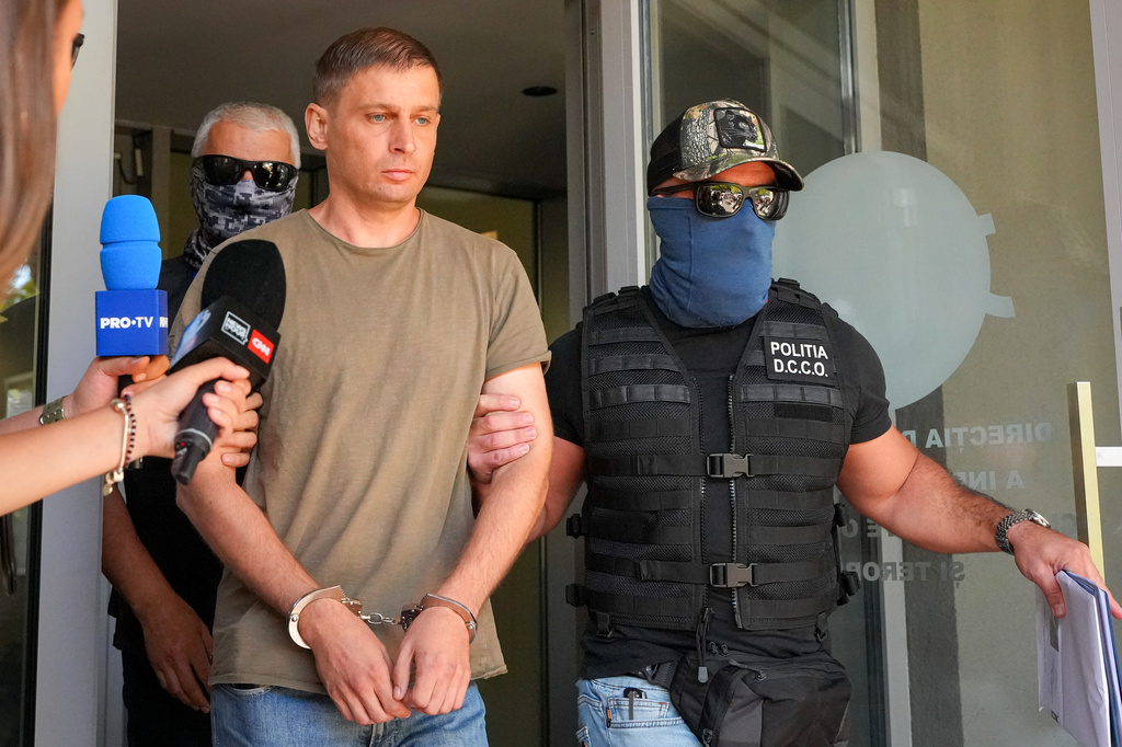 Police officers escort a Russian citizen, investigated for committing the crime of attempted sabotage after he was detained by prosecutors from Romania's Directorate for Investigating Organised Crime and Terrorism, DIICOT, in Bucharest, Romania, Tuesday, Sept. 8, 2026. (AP Photo/ Vadim Ghirda)