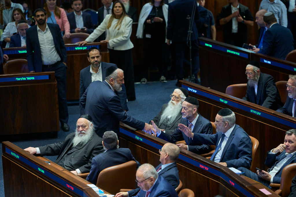 Israeli lawmakers attend a parliament session after the vote on a bill that seeks to equate the study of Jewish texts with military service, in Jerusalem, Monday, July 13, 2026. (AP Photo/Ohad Zwigenberg)