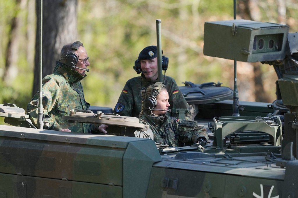 German Chancellor Friedrich Merz, left, drives in the armoured fighting vehicle Boxer during his visit to the army at the Bundeswehr base in Munster, Germany, Thursday, April, 30, 2026. (AP Photo/Markus Schreiber, Pool)