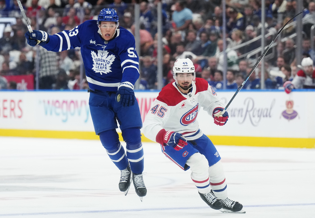 Toronto Maple Leafs' Easton Cowan (53) jumps out of the way of Montreal Canadiens' Alexandre Carrier (45) during the second period of an NHL hockey game against the Montreal Canadiens in Toronto, Tuesday, Sept. 29, 2026. (Nathan Denette/The Canadian Press via AP)