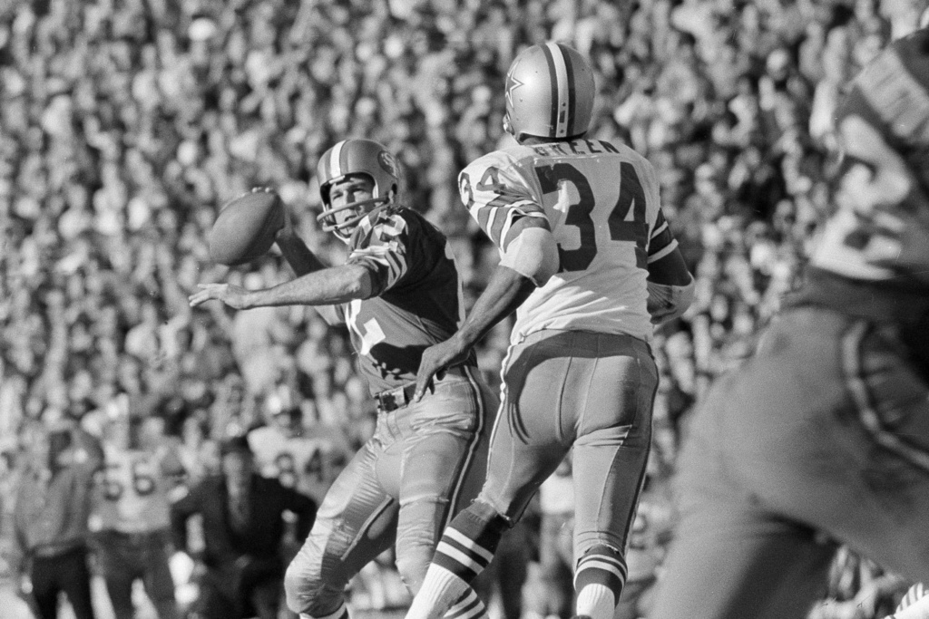 FILE - San Francisco 49ers quarterback John Brodie looks to pass as Dallas Cowboys' Cornell Green (34) defends during the NFC championship game in San Francisco, Jan. 3, 1971. (AP Photo/File)