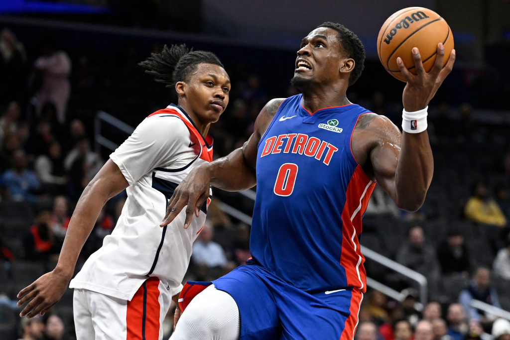 Detroit Pistons center Jalen Duren (0) goes to shoot past Washington Wizards guard Bub Carrington during the second half of an NBA basketball game, Tuesday, March 17, 2026, in Washington. (AP Photo/John McDonnell)