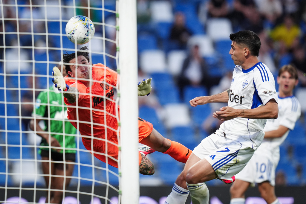 Sassuolo's goalkeeper Stefano Turati dives for the ball in front of Como's Nico Paz during the Serie A soccer match between Sassuolo and Como, Friday, April 17, 2026 in Reggio Emilia, Italy. (Massimo Paolone/LaPresse via AP)