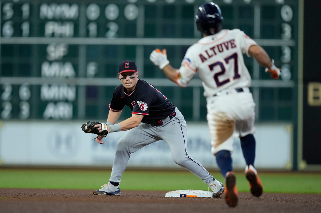 Cleveland Guardians second baseman Travis Bazzana, left, waits to tag out Houston Astros' Jose Altuve (27) who was trying to stretch a single into a double during the fourth inning of a baseball game Saturday, June 20, 2026, in Houston. (AP Photo/Kevin M. Cox)