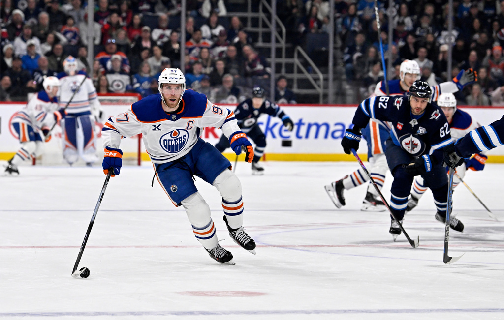 Edmonton Oilers' Connor McDavid (97) carries the puck toward the Winnipeg Jets net during the first period of an NHL hockey game in Winnipeg, Manitoba, Monday, Dec. 29, 2025. (Fred Greenslade/The Canadian Press via AP)