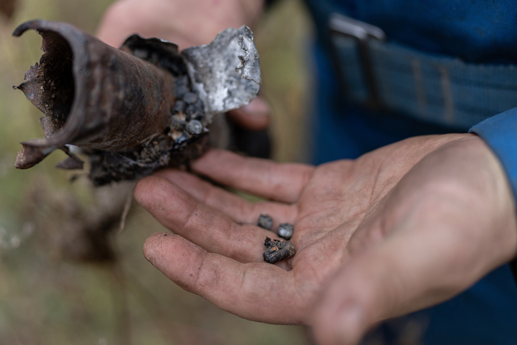 Oleksandr Leheda, 49, a power line repairman for Chernihiv Oblenergo, holds a Russian weapon that exploded near damaged power lines that his brigade was supposed to repair that day, Friday, Oct. 17, 2025, in Chernihiv, Ukraine. (AP Photo/Julia Demaree Nikhinson)