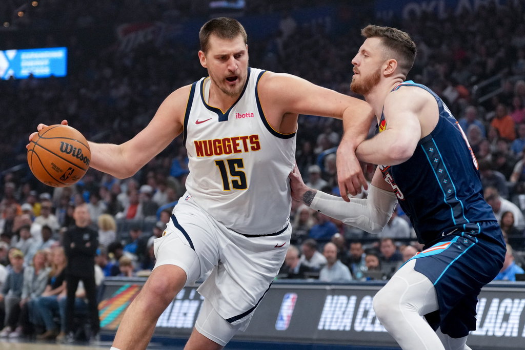 Denver Nuggets center Nikola Jokic, left, drives past Oklahoma City Thunder center Isaiah Hartenstein, right, during the first half of an NBA basketball game, Friday, Feb. 27, 2026, in Oklahoma City. (AP Photo/Kyle Phillips)