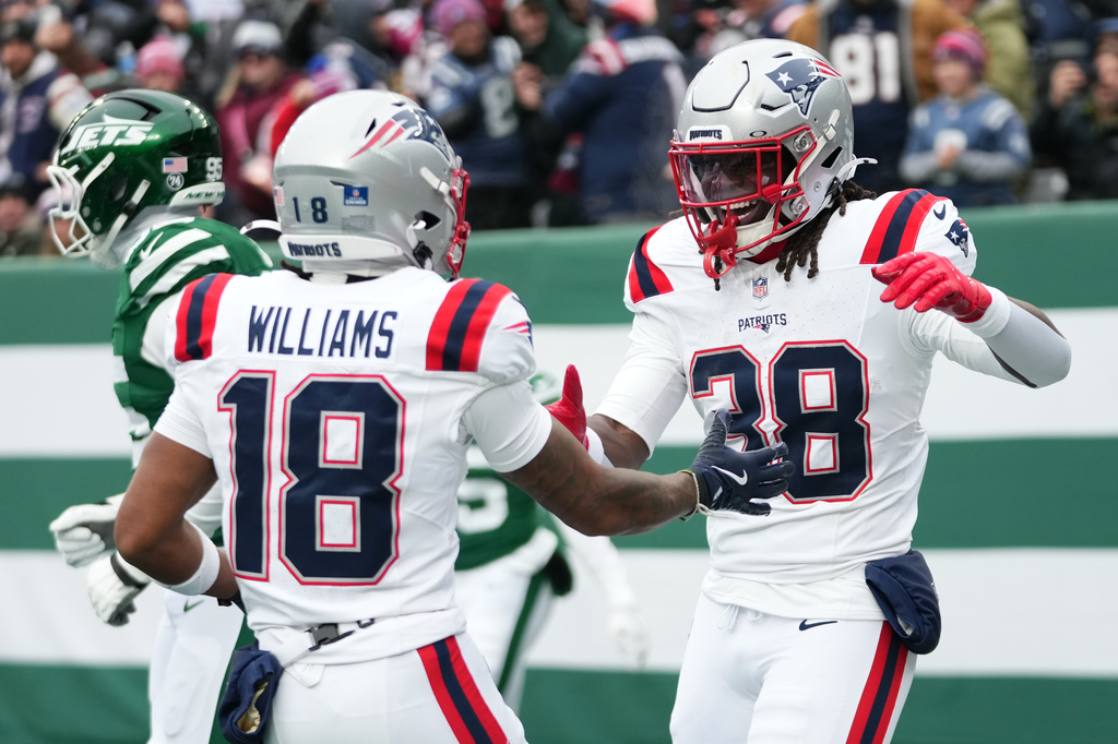 New England Patriots running back Rhamondre Stevenson (38) celebrates a touchdown against the New York Jets with teammate Kyle Williams (18) during the first half of an NFL football game, Sunday, Dec. 28, 2025, in East Rutherford, N.J. (AP Photo/Frank Franklin)