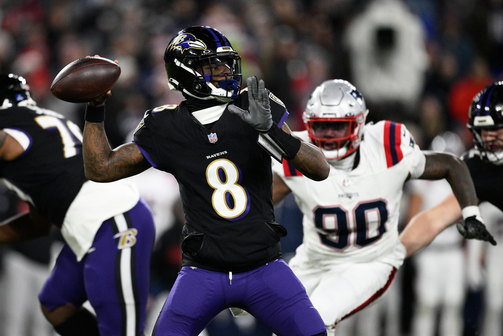 Baltimore Ravens quarterback Lamar Jackson (8) passes as New England Patriots defensive tackle Christian Barmore (90) applies pressure during the first half of an NFL football game, Sunday, Dec. 21, 2025, in Baltimore. (AP Photo/Nick Wass)
