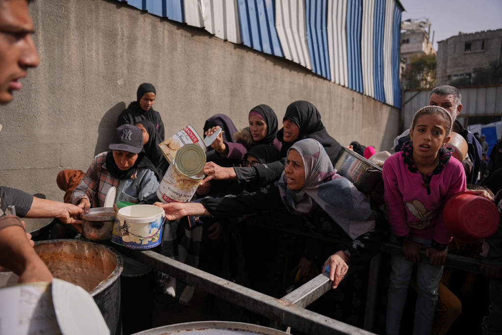 FILE - Palestinian women receive donated food at a community kitchen in Nuseirat, in central Gaza Strip, Saturday, Jan. 24, 2026. (AP Photo/Abdel Kareem Hana, File)