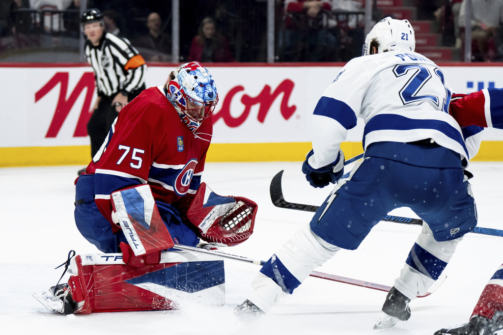 Montreal Canadiens goaltender Jakub Dobes (75) makes a save against Tampa Bay Lightning' Brayden Point (21) during the second period of an NHL hockey game in Montreal on Thursday, April 9, 2026. (Christopher Katsarov/The Canadian Press via AP)
