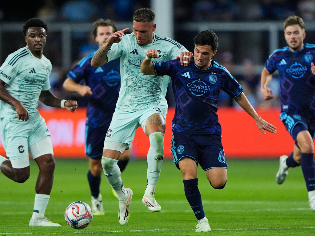 Colorado Rapids forward Rafael Navarro, center left, and Sporting Kansas City midfielder Manu Garcia (6) battle for the ball during the first half of an MLS soccer match Saturday, March 21, 2026, in Kansas City, Kan. (AP Photo/Charlie Riedel)