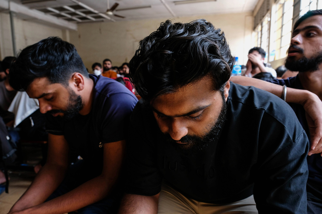 Detainees sit in a room after Ugandan authorities arrested dozens of foreigners in a crackdown on illegal migration in Kampala, Uganda, Tuesday, April 28, 2026. (AP Photo/Hajarah Nalwadda)