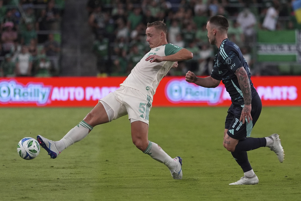 Austin FC defender Marius Hoibraten (5) moves the ball past Seattle Sounders' Albert Rusnak (11) during the second half of an MLS soccer match in Austin, Texas, Sunday, Sept. 21, 2025. (AP Photo/Eric Gay)
