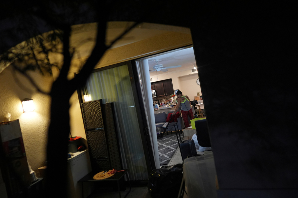 FILE - Maria, a Venezuelan immigrant who lives with her U.S. citizen husband and two daughters who have Temporary Protected Status, or TPS, vacuums a rug as the family organizes and packs for their upcoming move into a larger apartment on April 5, 2025, in Doral, Fla. (AP Photo/Rebecca Blackwell, File)