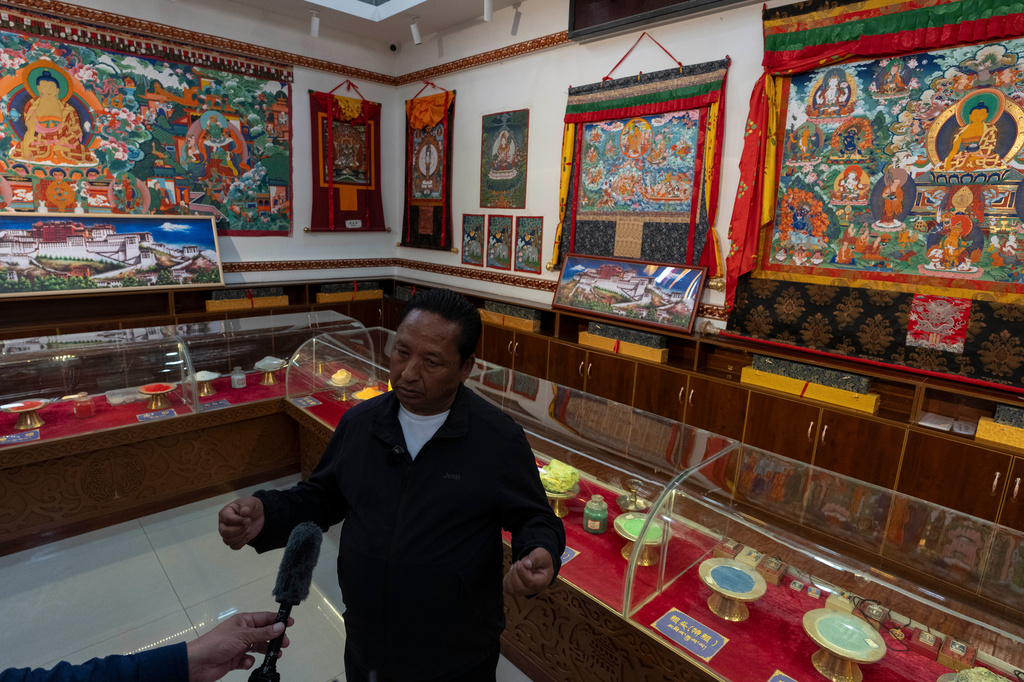Pasang, founder of the Ethnic Huaji Handwoven Cooperative, is interviewed in a showroom of the products in Shannan in western China's Tibet Autonomous Region on July 23, 2026, as seen during a government organized visit for foreign journalists. (AP Photo/Ng Han Guan)