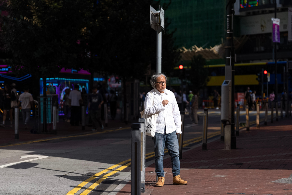 Artist Sanmu Chen displays a red thread as he performs on the street in the Causeway Bay area on the eve of the 37th anniversary of China's Tiananmen Square crackdown in Hong Kong, Wednesday, June 3, 2026. (AP Photo/Chan Long Hei)