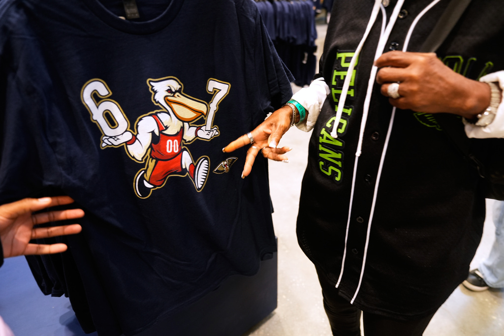 FILE - Tori McCray, left, and her grandmother Alberta Tolliver look over a 6-7 T-shirt in a merchandise shop inside the Smoothie King Center during the second half of an NBA basketball game between the New Orleans Pelicans and the Memphis Grizzlies, Jan. 30, 2026, in New Orleans. (AP Photo/Gerald Herbert, file)