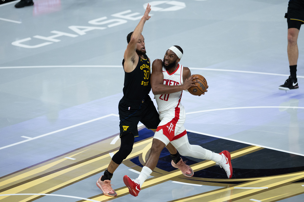 Houston Rockets guard Josh Okogie is guarded by Golden State Warriors guard Stephen Curry during the first half of an Emirates NBA Cup basketball game Wednesday, Nov. 26, 2025, in San Francisco. (AP Photo/Benjamin Fanjoy)