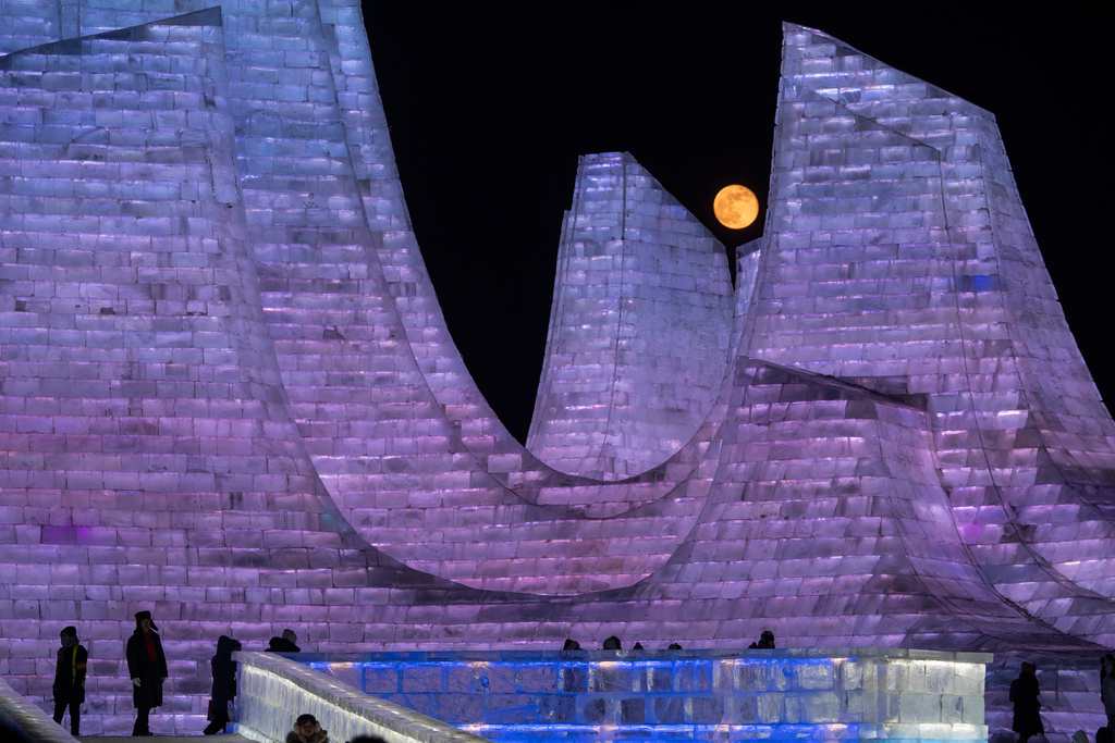 A Wolf Supermoon rises over ice structures at the annual Ice and Snow Festival held in Harbin in China's Heilongjiang province on Sunday, Jan. 4, 2026. (AP Photo/Ng Han Guan)
