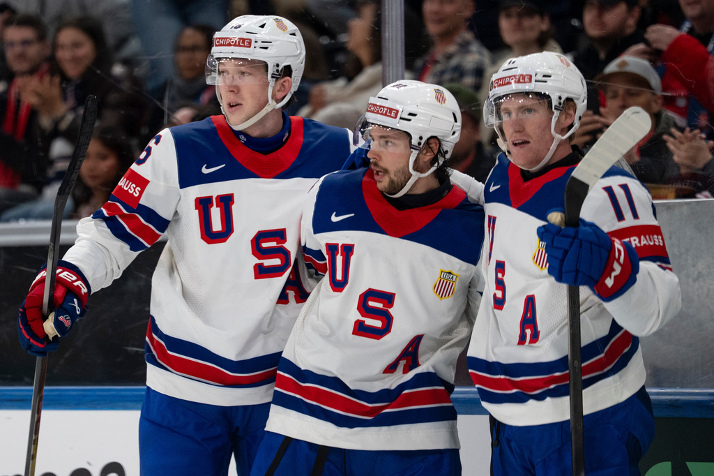 From left, USA's Mason Lohrei, Isaac Howard and Oliver Moore celebrate after their team's second goal, during the 2026 IIHF Men's Ice Hockey World Championship preliminary round group A game between Britain and the United States, in Zurich, Switzerland, Sunday, May 17, 2026. (Claudio Thoma/Keystone via AP)