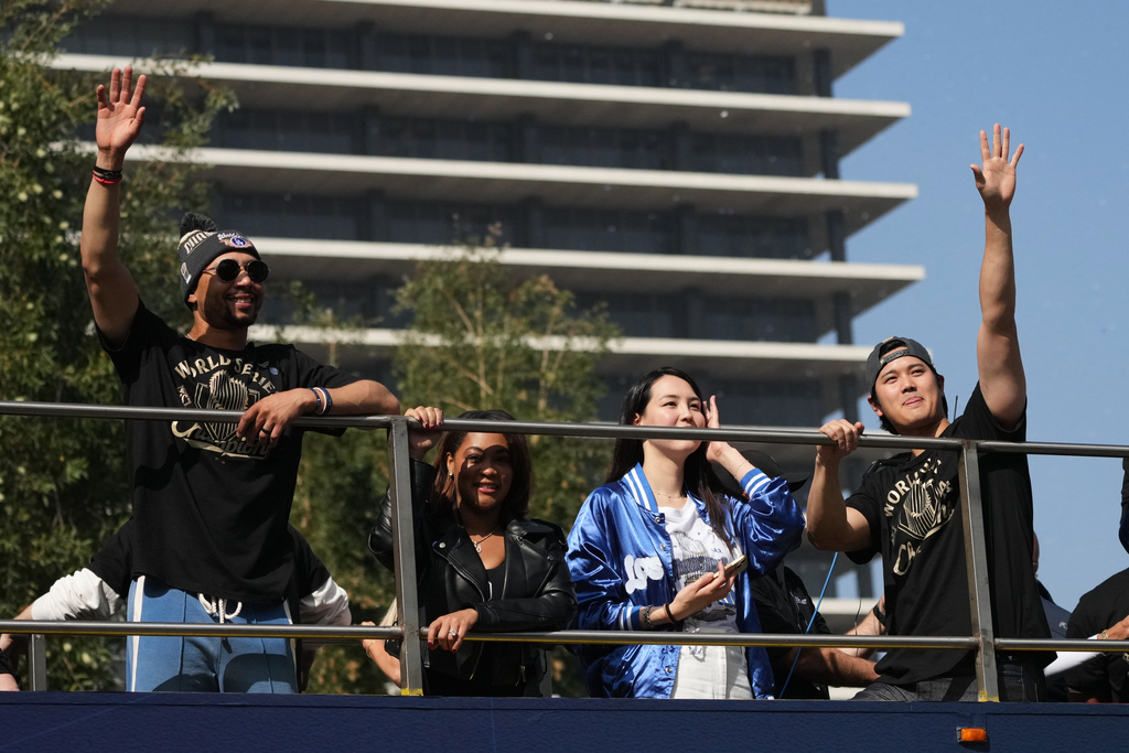 Los Angeles Dodgers' Mookie Betts, left, and Shohei Ohtani wave at fans during a parade to celebrate the baseball team's World Series win on Monday, Nov. 3, 2025, in Los Angeles. (AP Photo/Jae C. Hong)