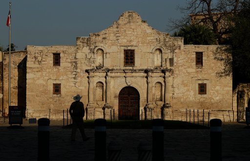 FILE - A ranger patrols the ground of the Alamo in San Antonio, Thursday, March 26, 2020. (AP Photo/Eric Gay, File) FILE - A ranger patrols the ground of the Alamo in San Antonio, Thursday, March 26, 2020. (AP Photo/Eric Gay, File)