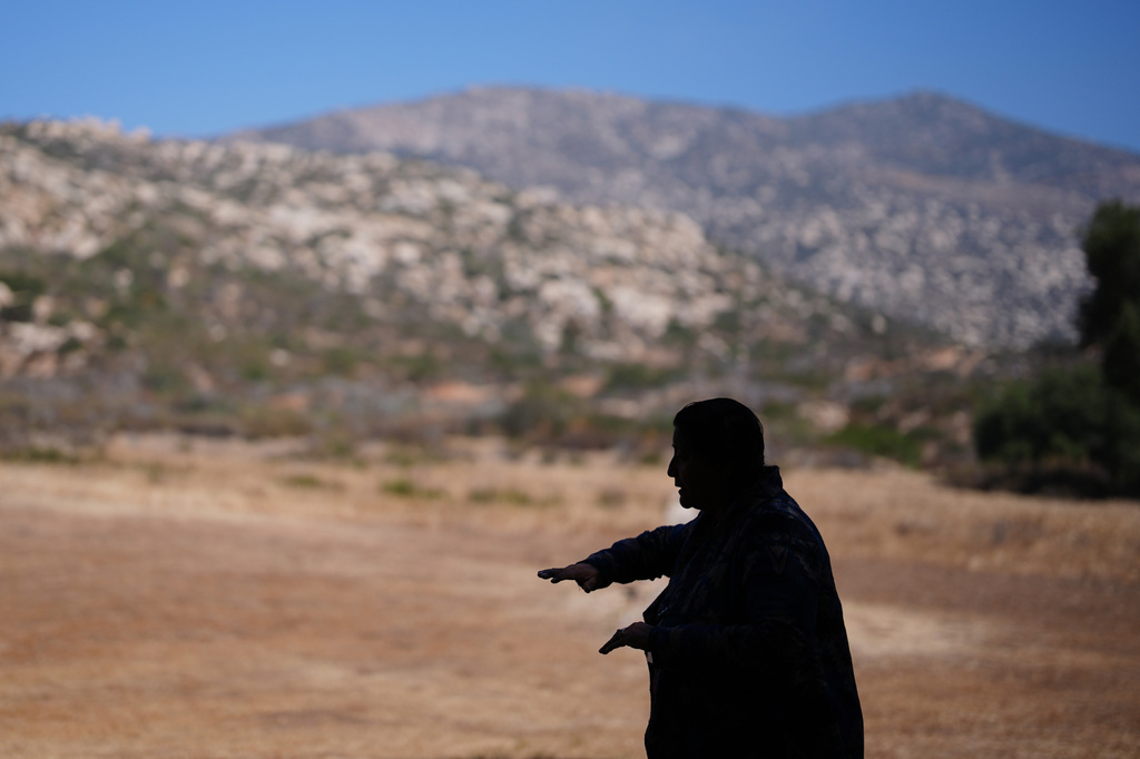 Norma Meza Calles, a Kumeyaay Nation leader, gestures as she speaks of the sacred importance of Kuuchamaa Mountain, behind, at a wellness center, Friday, May 1, 2026, in Tecate, Mexico. (AP Photo/Gregory Bull)