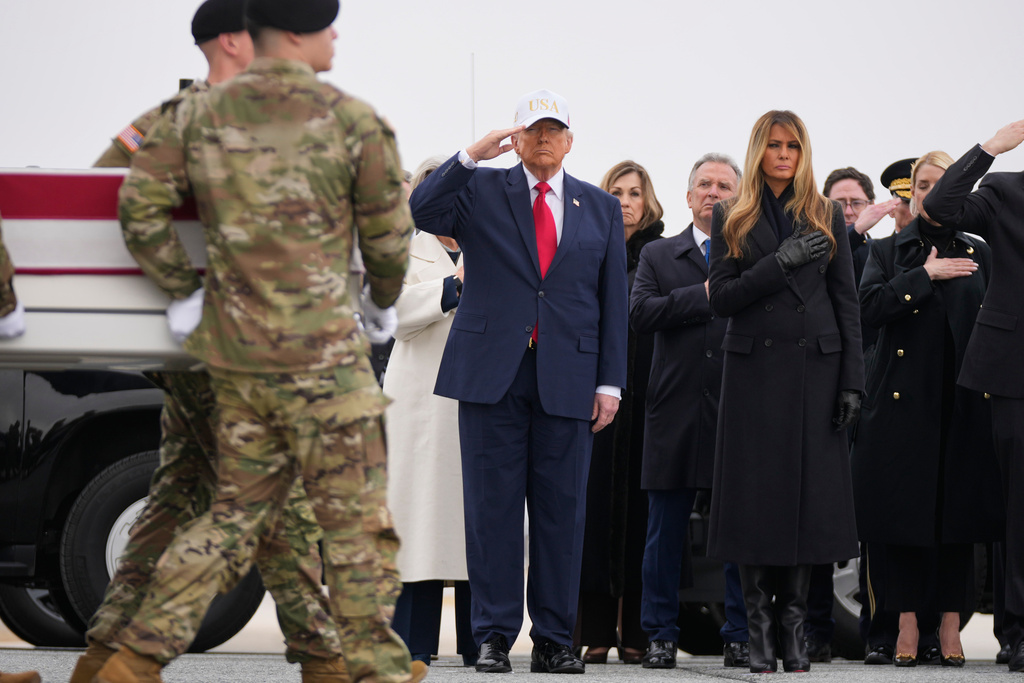 An Army carry team moves a flag-draped transfer case with the remains of U.S. Army Reserve soldier Sgt. 1st Class Nicole Amor, of White Bear Lake, Minn., who was killed in a drone strike at a command center in Kuwait after the U.S. and Israel launched its military campaign against Iran, past President Donald Trump and first lady Melania Trump during a casualty return, Saturday, March 7, 2026, at Dover Air Force Base, Del. (AP Photo/Mark Schiefelbein)