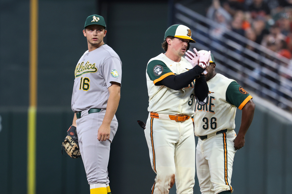 Baltimore Orioles' Adley Rutschman, center, gettures towards the dugout after hitting a single against Athletics pitcher Jacob Lopez during the first inning of a baseball game, Friday, May 8, 2026, in Baltimore. (AP Photo/Terrance Williams)