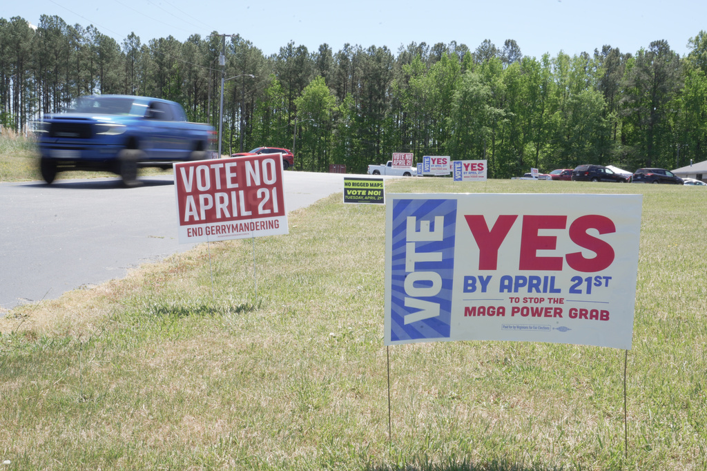 A truck passes political signs outside a polling place at Good Shepherd Catholic Church in South Hill, Va., on Tuesday, April 21, 2026. (AP Photo/Allen G. Breed)