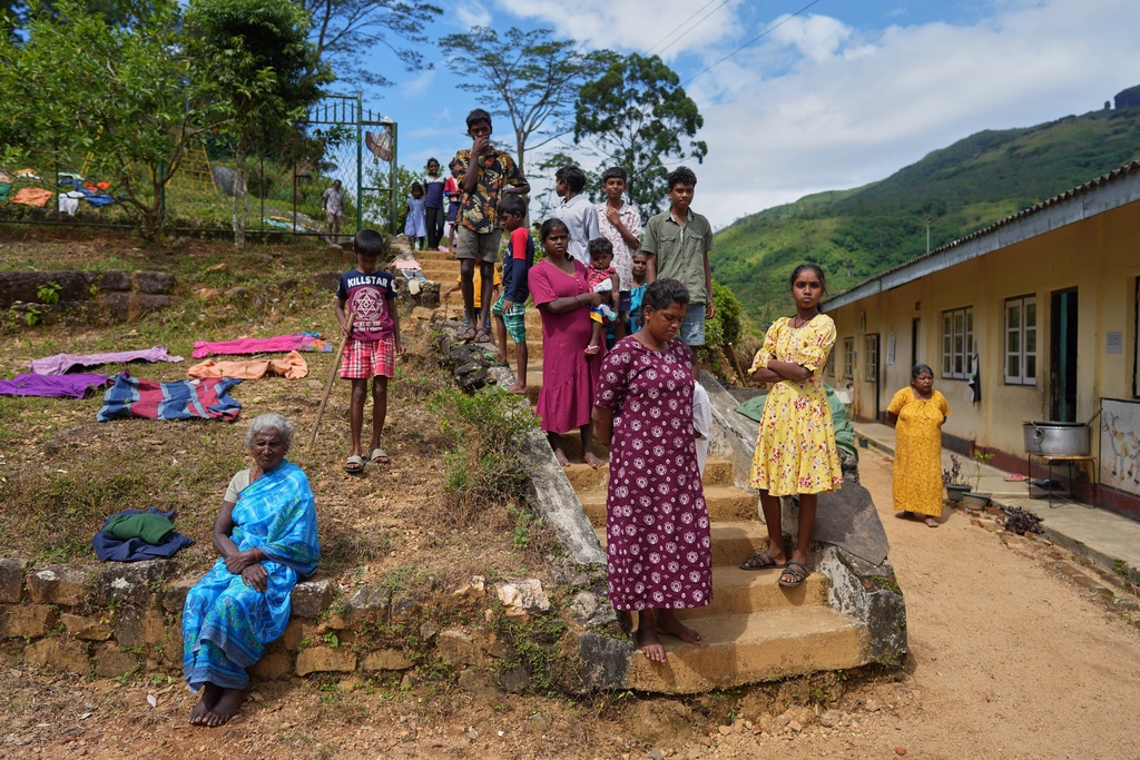 Tea plantation workers evacuated after Cyclone Ditwah led to floods and landslides spend time out of a safety center in Galamuduna Estate in Dolosbage, Sri Lanka, Friday, Dec. 12, 2025. (AP Photo/Eranga Jayawardena)