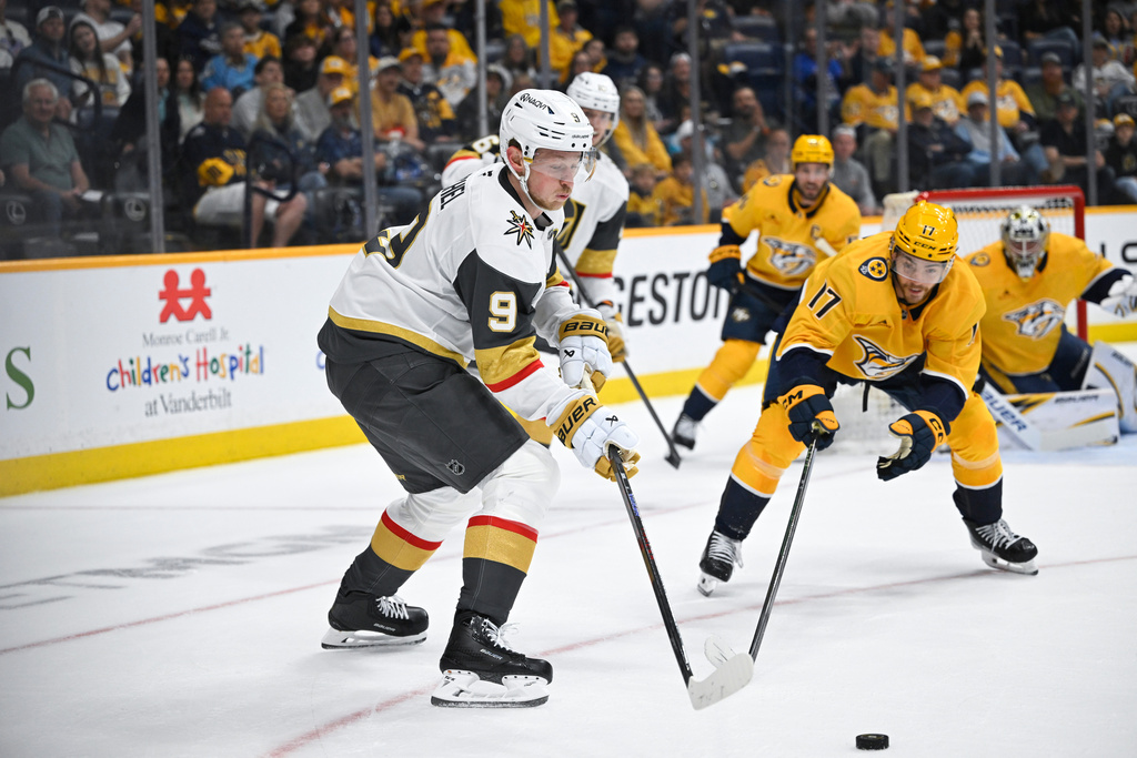 Vegas Golden Knights center Jack Eichel (9) and Nashville Predators center Tyson Jost (17) vie for the puck during the first period of an NHL hockey game Saturday, March 21, 2026, in Nashville, Tenn. (AP Photo/John Amis)