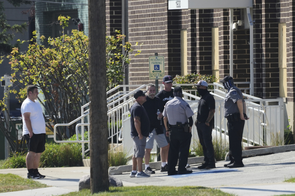 People talk with federal agents and security guards outside of an ICE (U.S. Immigration and Customs Enforcement) processing facility in the Chicago suburb of Broadview, Ill., Wednesday, Sept. 17, 2025. (AP Photo/Nam Y. Huh)
