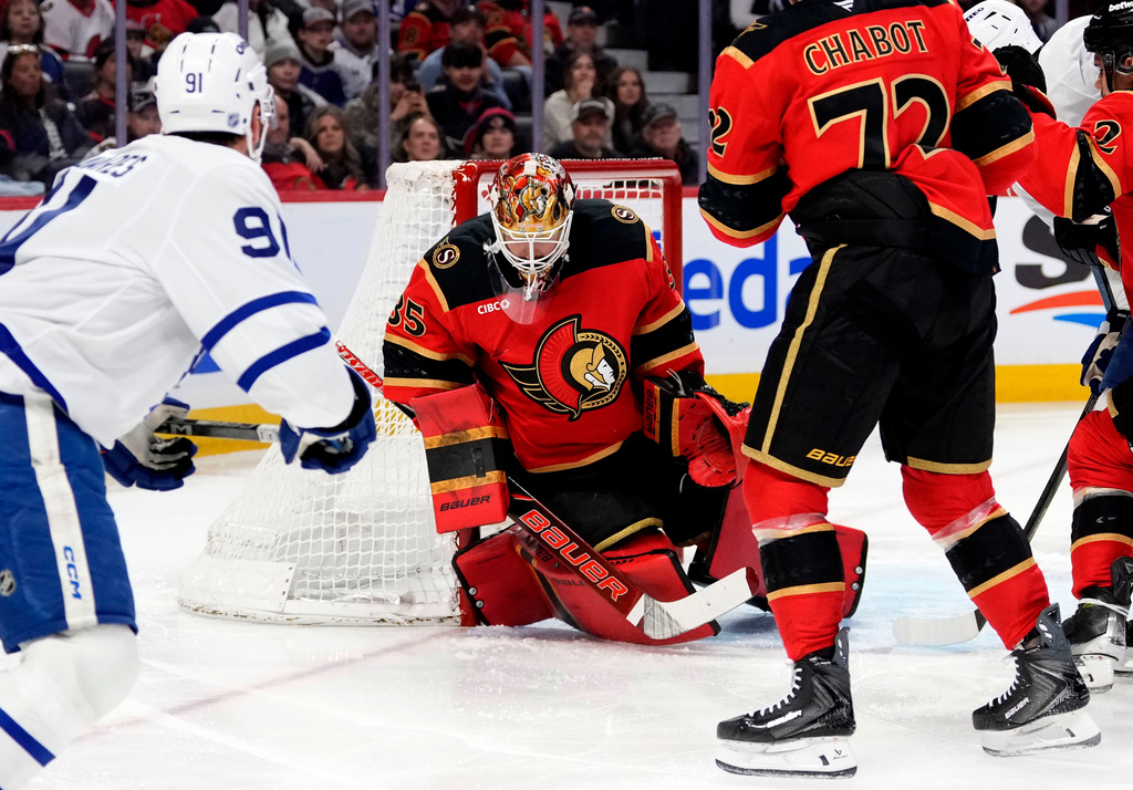 Ottawa Senators goaltender Linus Ullmark, center, makes a blocker save against Toronto Maple Leafs' John Tavares (91) during first-period NHL hockey game action in Ottawa, Ontario, Saturday, March 21, 2026. (Justin Tang/The Canadian Press via AP)
