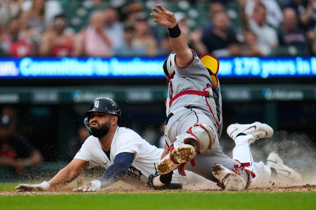 Detroit Tigers' Riley Greene, right, slides safely into home plate ahead of the tag of Cleveland Guardians catcher Austin Hedges, left, during the fourth inning of a baseball game Tuesday, May 19, 2026, in Detroit. (AP Photo/Paul Sancya)