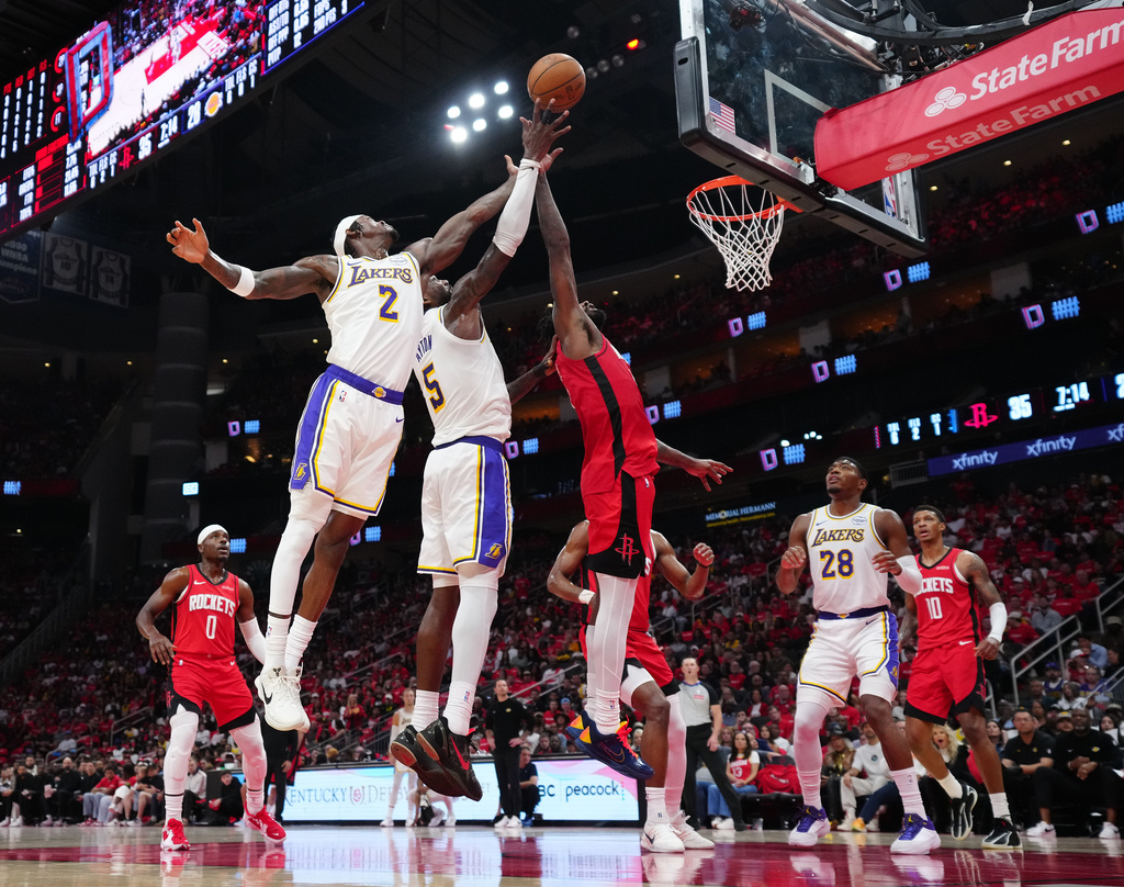 Los Angeles Lakers' Jarred Vanderbilt (2) and Deandre Ayton (5) go up for a rebound against Houston Rockets forward Tari Eason, right, during the first half in Game 4 of a first-round NBA basketball playoffs series, Sunday, April 26, 2026, in Houston. (AP Photo/Karen Warren)
