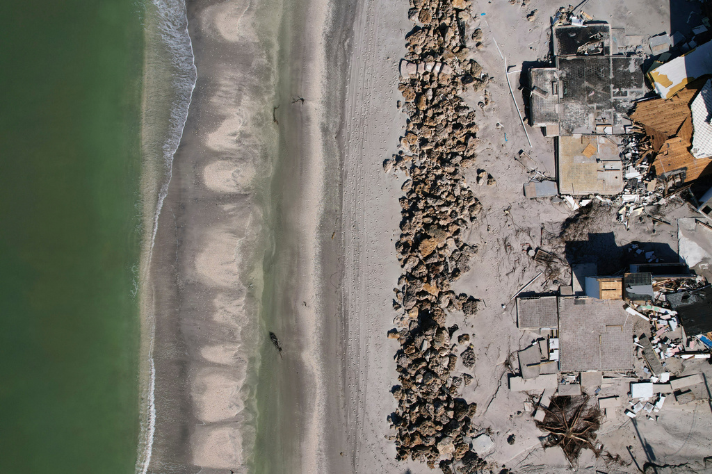 FILE - Waves lap on the beach in front of empty house foundations surrounded by debris, following the passage of Hurricane Milton, on Manasota Key, in Englewood, Fla., Oct. 13, 2024. (AP Photo/Rebecca Blackwell, File)