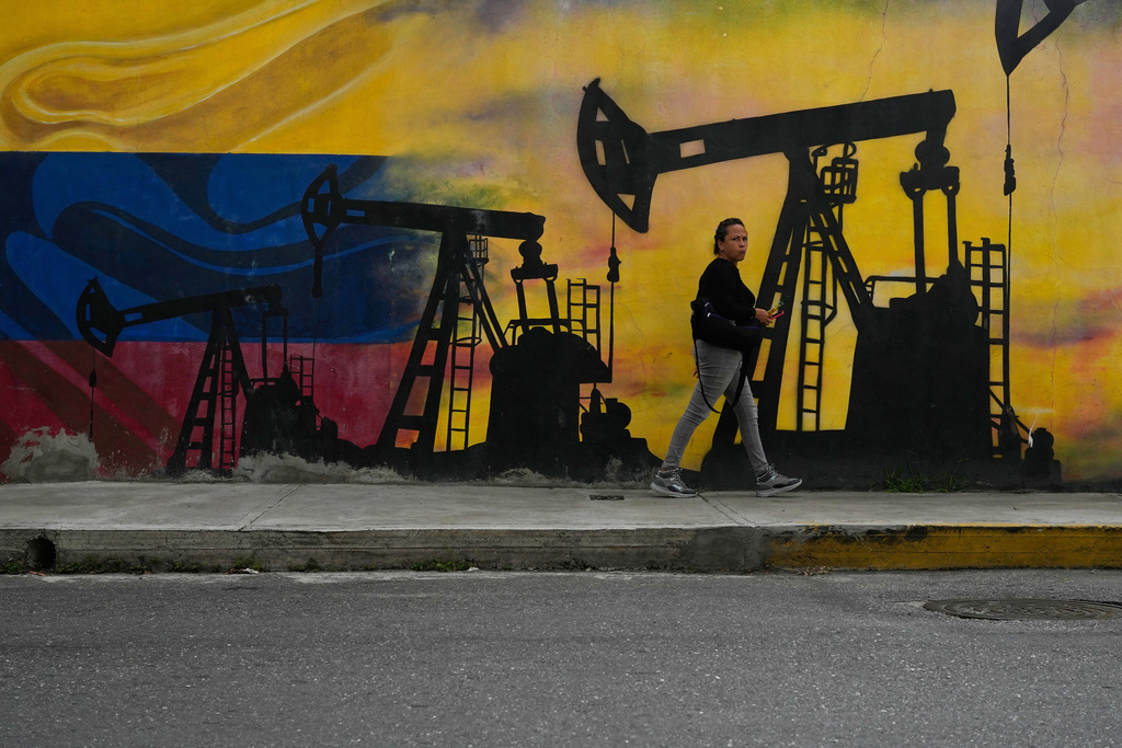 FILE - A local walks past a mural featuring oil pumps and wells in Caracas, Venezuela, Jan. 6, 2026. (AP Photo/Matias Delacroix, File)