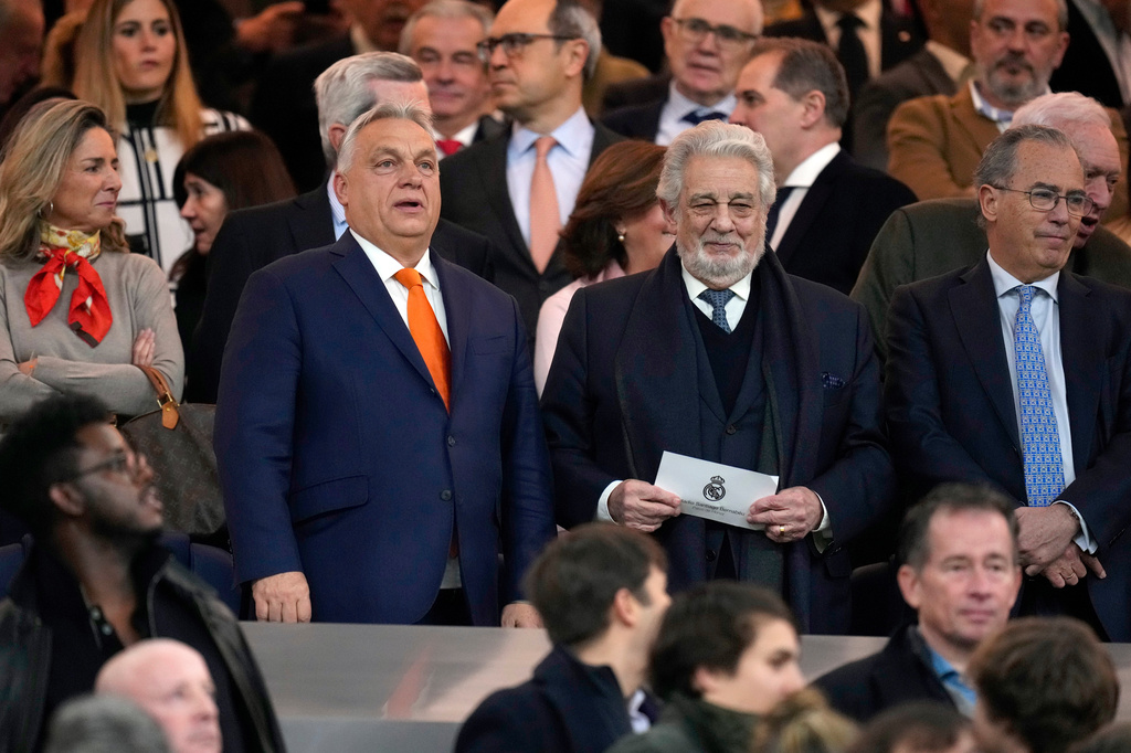 FILE - Hungarian Prime Minister Viktor Orban, center left, and Spanish opera singer Placido Domingo, center right, wait for the start of a Spanish La Liga soccer match between Real Madrid and Atletico Madrid at the Santiago Bernabeu stadium in Madrid, Saturday, Feb. 8, 2025. (AP Photo/Manu Fernandez, File)