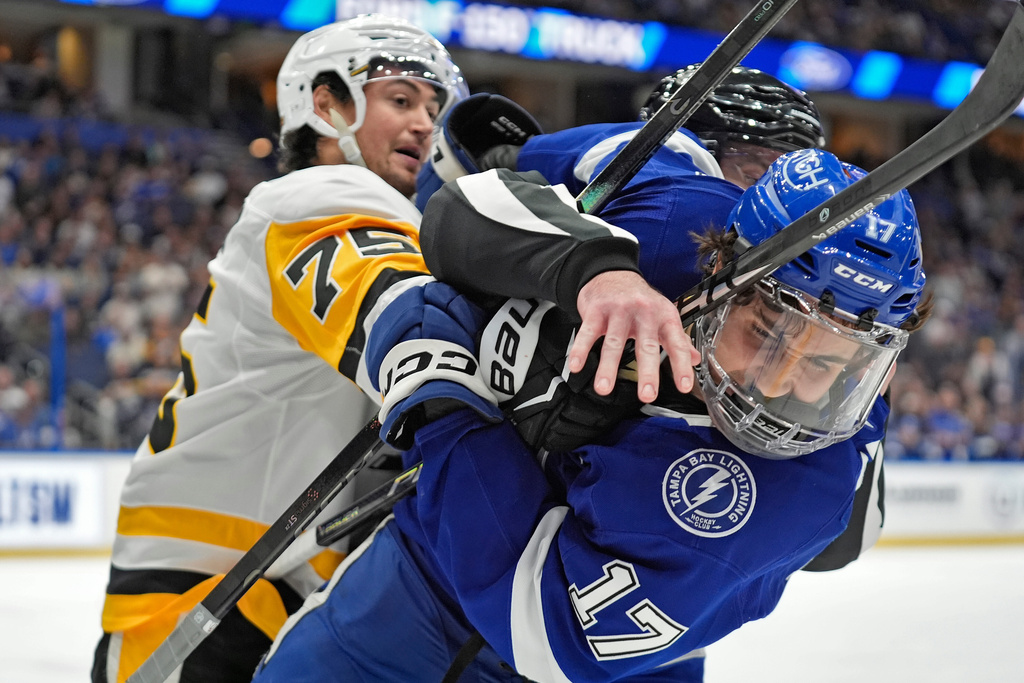 Tampa Bay Lightning center Dominic James (17) and Pittsburgh Penguins defenseman Connor Clifton (75) scrap during the second period of an NHL hockey game Thursday, Dec. 4, 2025, in Tampa, Fla. (AP Photo/Chris O'Meara)