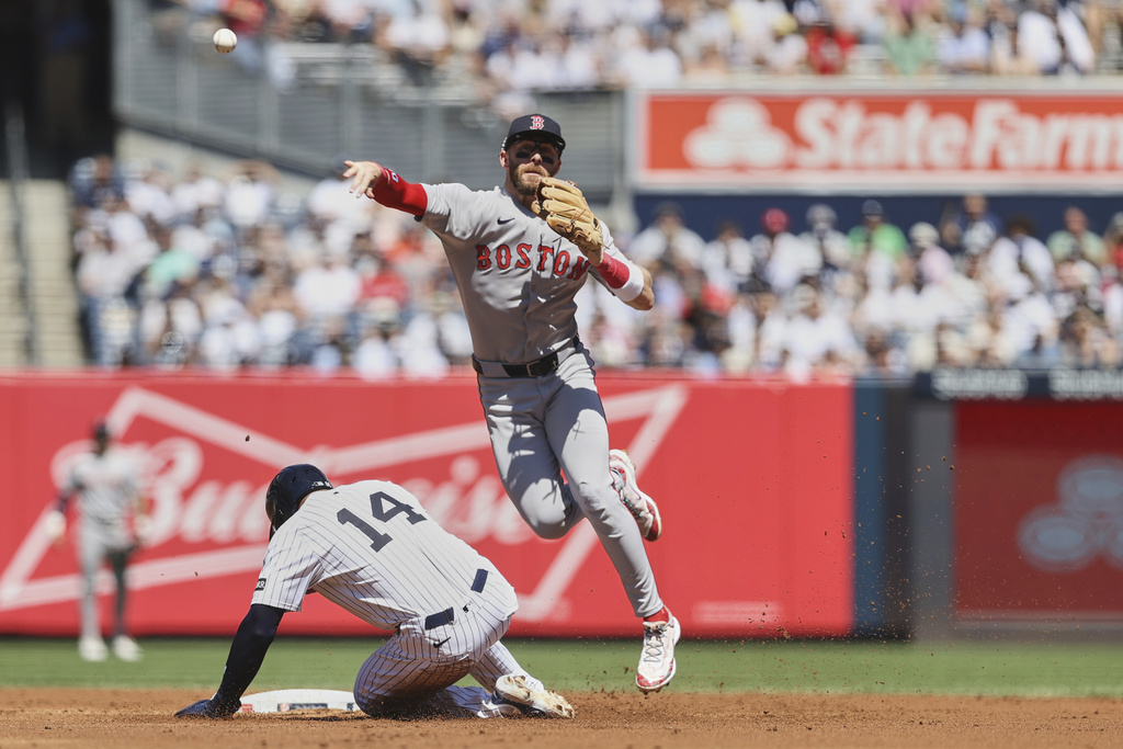 New York Yankees' Amed Rosario, left, is grounded out by Boston Red Sox shortstop Trevor Story, right, during the second inning of a baseball game Saturday, Aug. 23, 2025, in New York. (AP Photo/Pamela Smith)