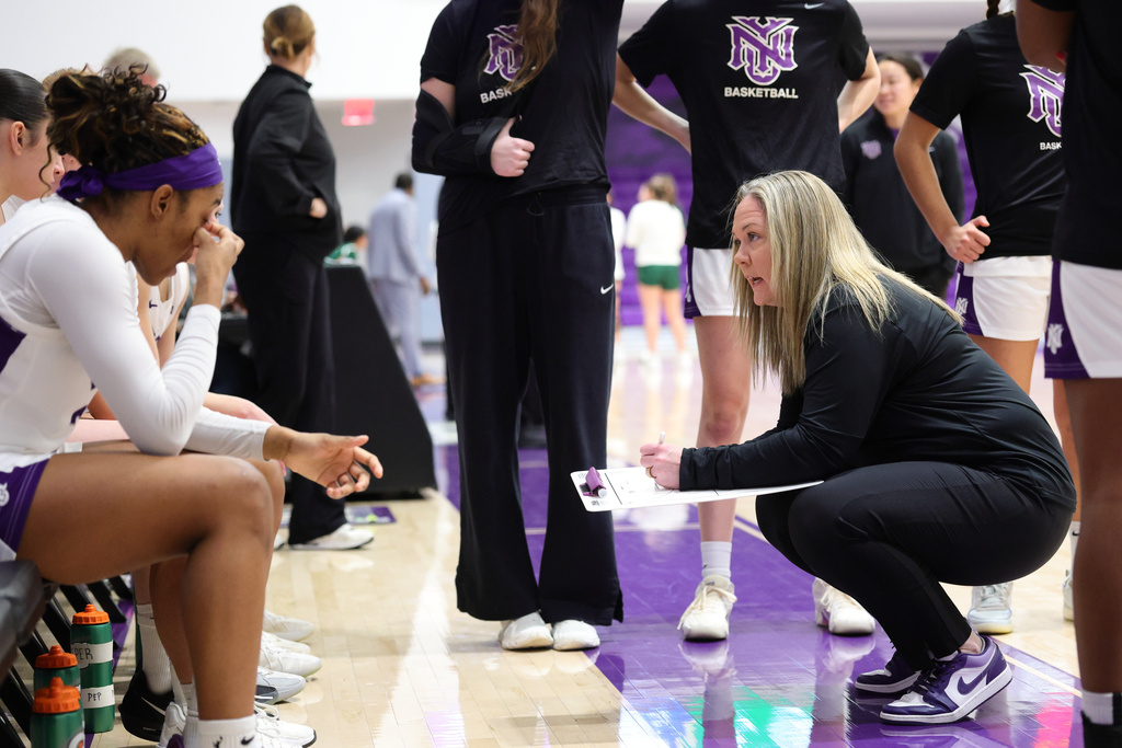 In this image provided by NYU Athletic Communications, NYU coach Meg Barber, right, talks to her players during an NCAA Div III college basketball game against Carnegie Mellon, Sunday, Feb. 1, 2026, in New York. (NYU Athletic Communications via AP)