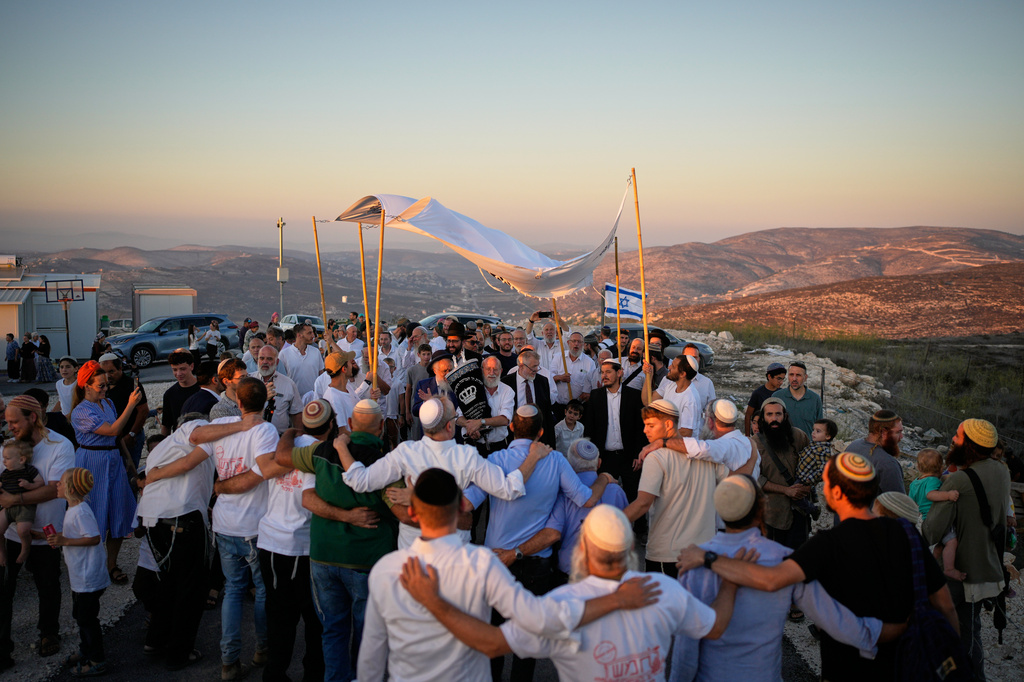 Israeli settlers celebrate the inauguration of a newly built synagogue at the occupied West Bank outpost of Homesh, Wednesday, Sept. 16, 2026. (AP Photo/Ohad Zwigenberg)